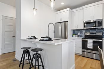 Kitchen with white counter and chairs